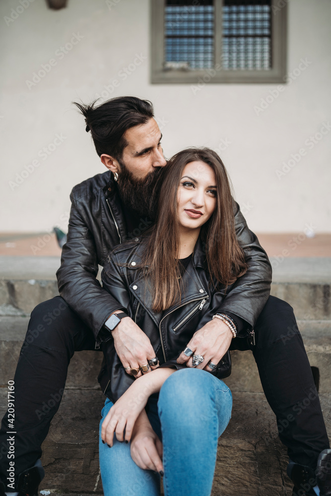 Man kissing hair and hugging woman from behind on steps Man kissing hair and hugging woman from behind on steps