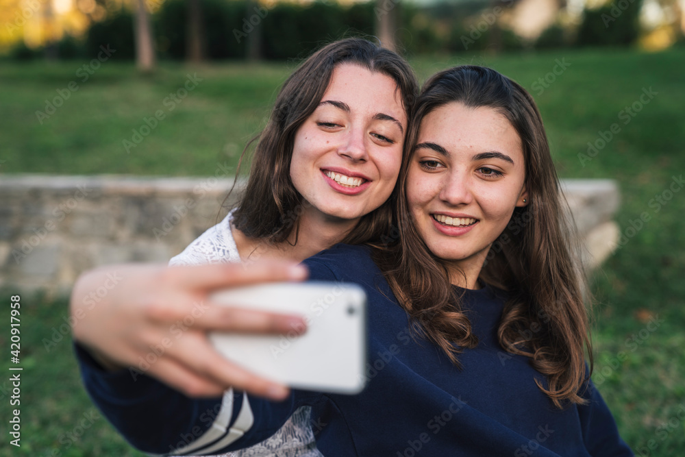 Sisters taking selfie in park Sisters taking selfie in park