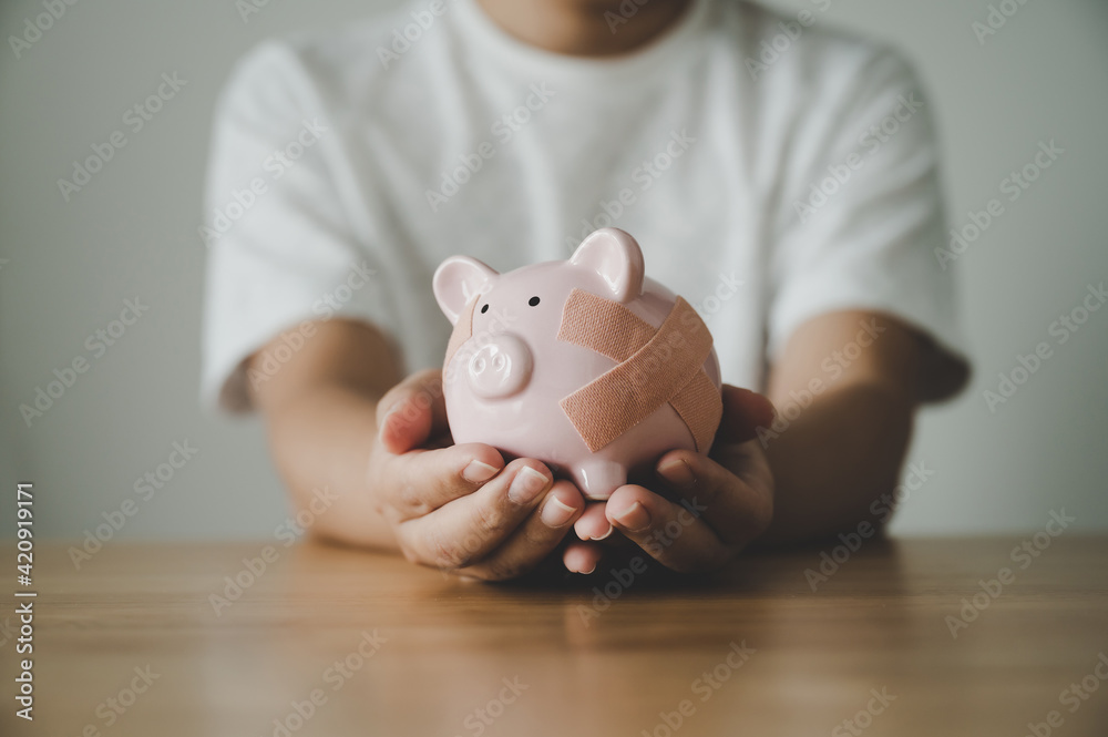 Man hand holding piggy bank on wooden table. Concept of save money and finance business investment - obrazy, fototapety, plakaty 