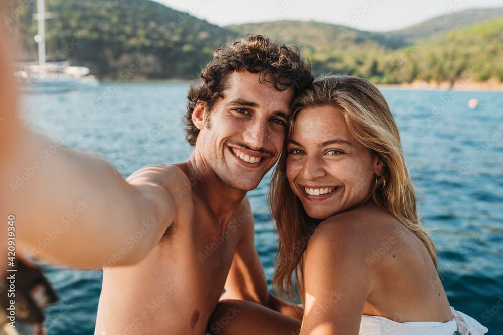 Couple taking selfie by seaside, Italy Couple taking selfie by seaside, Italy