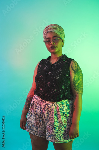 Young woman in turban posing against turquoise background photo