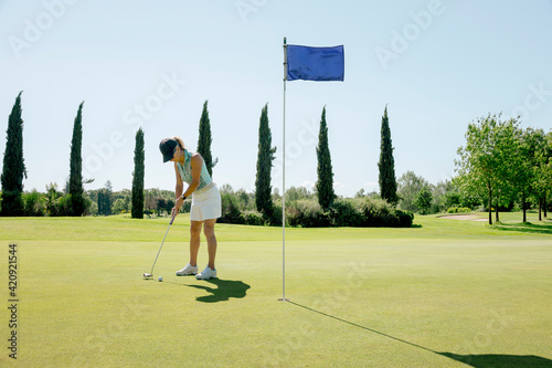 Woman playing golf on golf course photo