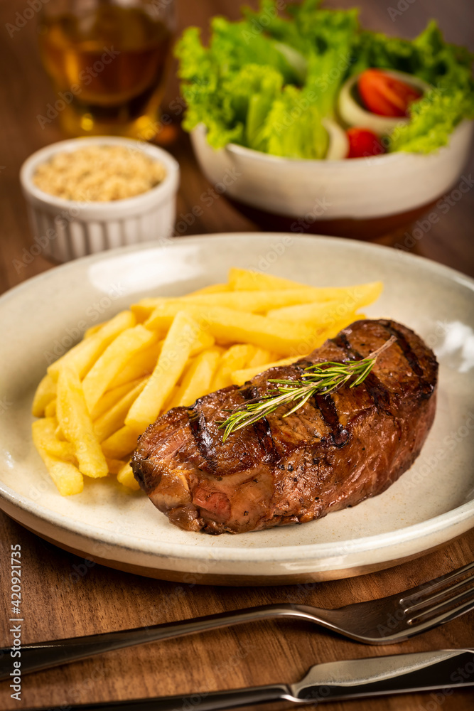 Grilled steak with french fries, brazilian farofa and salad.