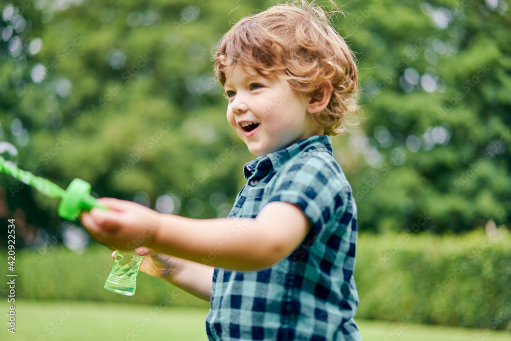 Toddler playing with soap bubbles in park Toddler playing with soap bubbles in park