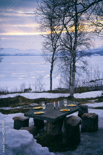 Outdoor table set with plates, wine glasses and candles in Vasterbottens Lan, Sweden.  photo