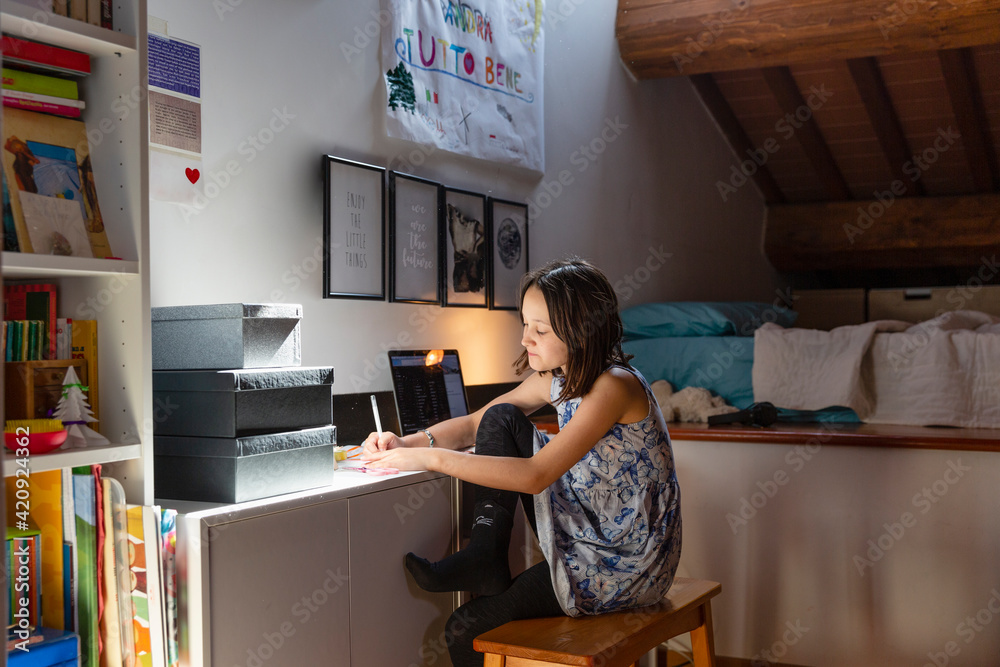 Girl sitting in her bedroom, doing homework during Coronavirus lockdown. Girl sitting in her bedroom, doing homework during Coronavirus lockdown.