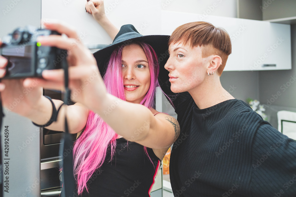 Young woman with long pink hair and woman with short red hair taking selfie. Young woman with long pink hair and woman with short red hair taking selfie.