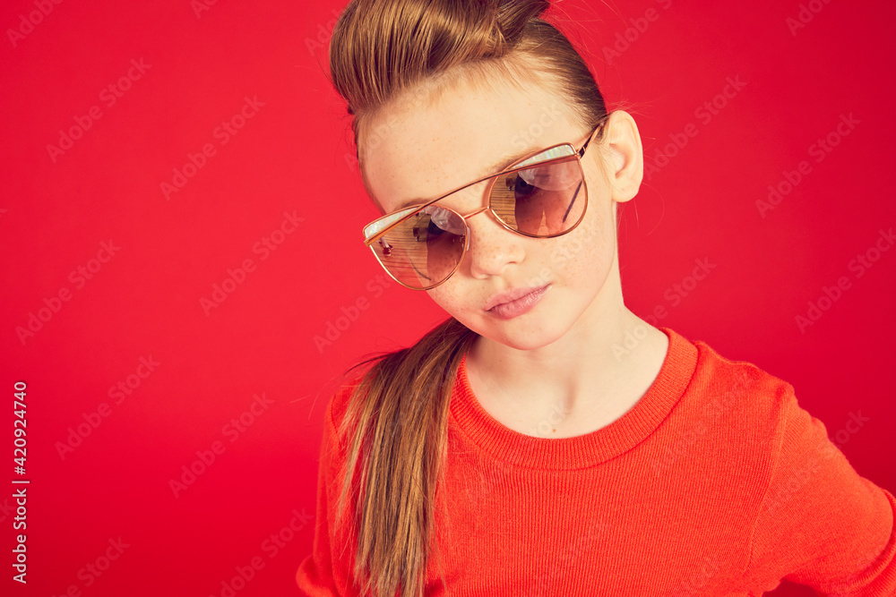 Portrait of brunette girl wearing red T-Shirt and sunglasses on red background, looking at camera. Portrait of brunette girl wearing red T-Shirt and sunglasses on red background, looking at camera.