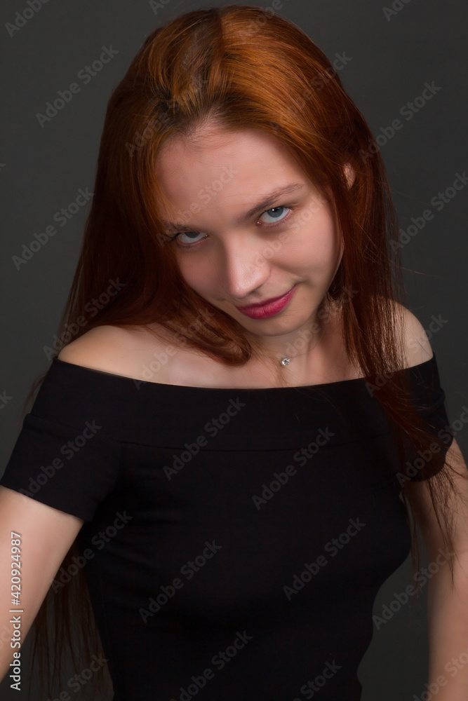 studio portrait of a young red-haired woman in black clothes studio portrait of a young red-haired woman in black clothes