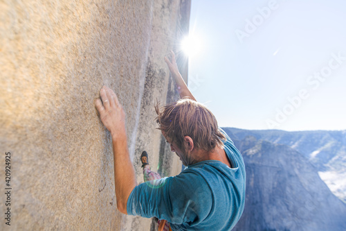 High angle view of mountaineer climbing up sheer wall of The Nose, El Capitan, Yosemite National Park. 