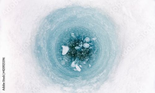 High angle close up of ice-fishing hole on frozen lake in Vasterbottens Lan, Sweden.
