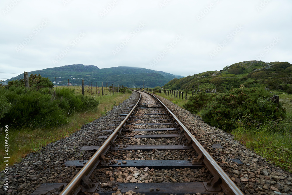View along a railway track in rural Wales on a cloudy day View along a railway track in rural Wales on a cloudy day