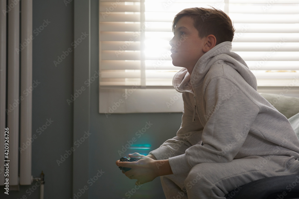 Boy sitting on a sofa in his pajamas, watching television. Boy sitting on a sofa in his pajamas, watching television.
