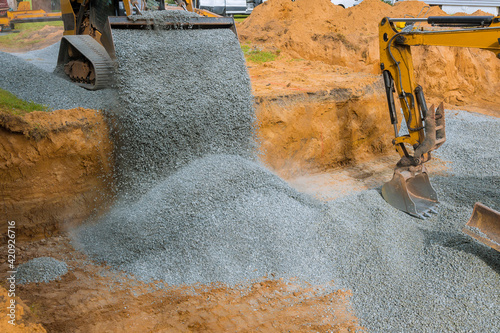 Foto Excavator bucket moving gravel stones for foundation building