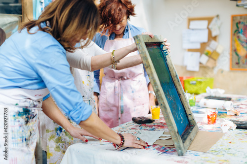 Artist teaching silk screen printing in creative studio photo