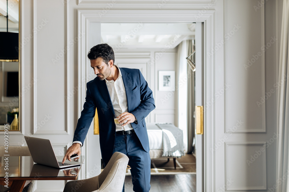 Businessman using laptop in suite Businessman using laptop in suite