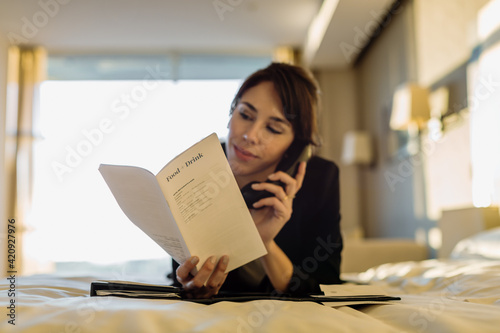 Businesswoman ordering room service in hotel photo