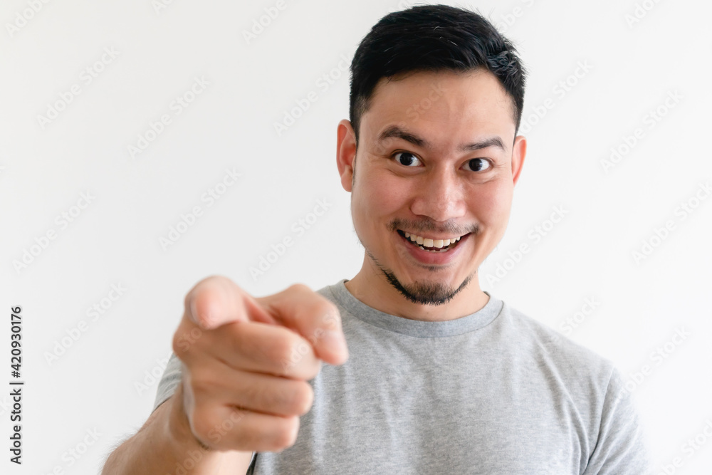 Asian man is pointing into the camera with an excited facial expression. Asian man is pointing into the camera with an excited facial expression.