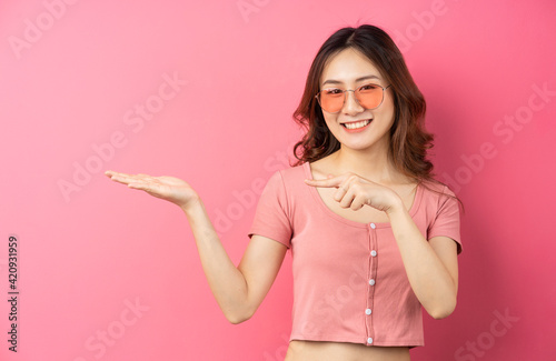 Young asian girl wearing glasses with cheerful expression on a pink background © Timeimage