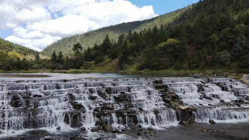 Terraced waterfall trucking drone footage in Potatso national park Yunnan China photo