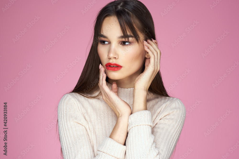 Pretty brunette in a white sweater red lips attractive look pink background Pretty brunette in a white sweater red lips attractive look pink background