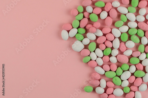 Sweet Dragee scattered on a pink background. © Mikhail