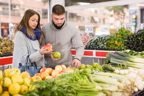 Glad couple choosing vegetables in grocery shop. High quality photo © JackF