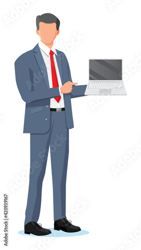 Business man holding laptop and pointing finger.