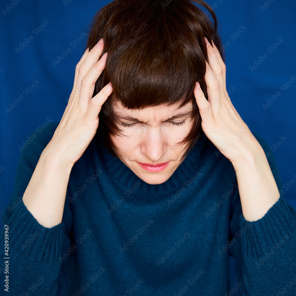 Portrait of mature woman in distress, close-up. Agitated tensed face. Middle-aged female frowning, clutching head in confusion, adult experienced lady looking uncertainly. Migraine. Mental health. Portrait of mature woman in distress, close-up. Agitated tensed face. Middle-aged female frowning, clutching head in confusion, adult experienced lady looking uncertainly. Migraine. Mental health.