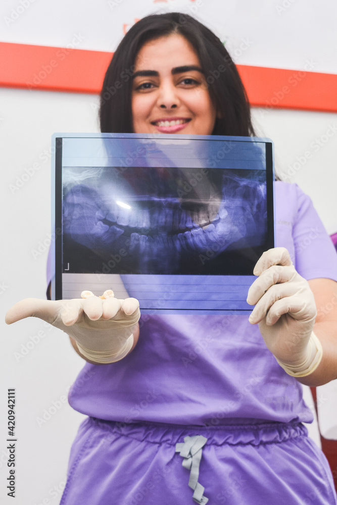 A female doctor showing a radiography xray. Una odontóloga mostrando
