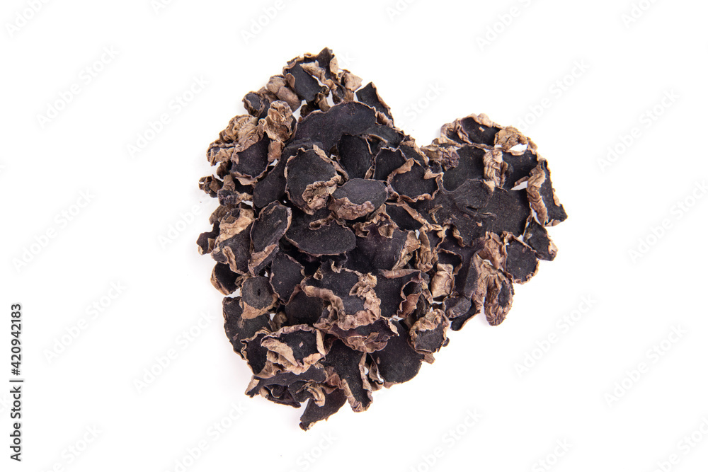 Dried black galingale slices arranged heart shape isolated on white background.top view,flat lay. Dried black galingale slices arranged heart shape isolated on white background.top view,flat lay.