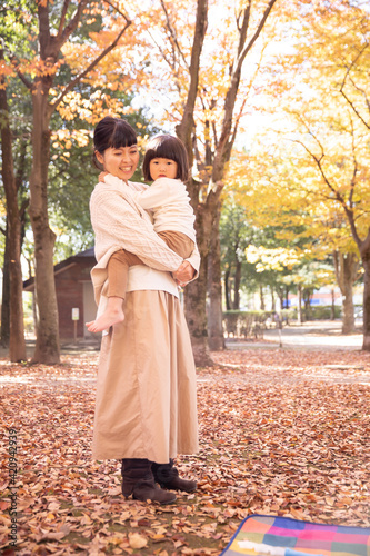 秋の公園で遊ぶママと子供 