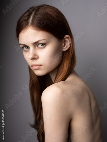 Pretty woman on gray background cropped view model red hair close up portrait