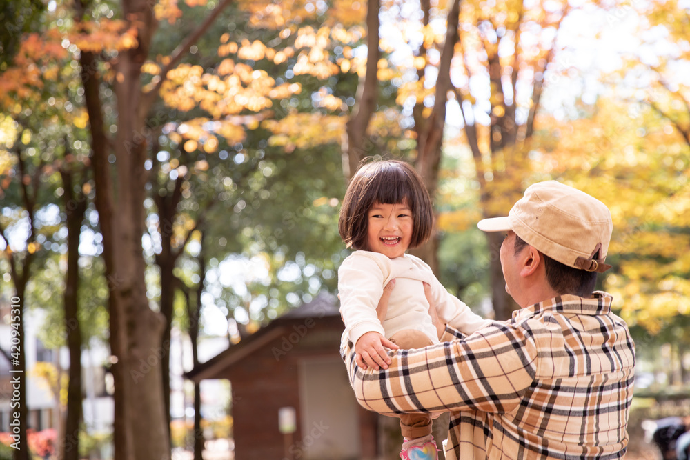Fototapeta premium 秋の公園で遊ぶ父親と子供 