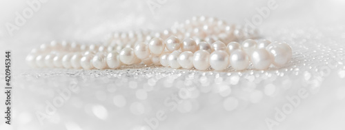 Nature white pearl beads on sparkling background.