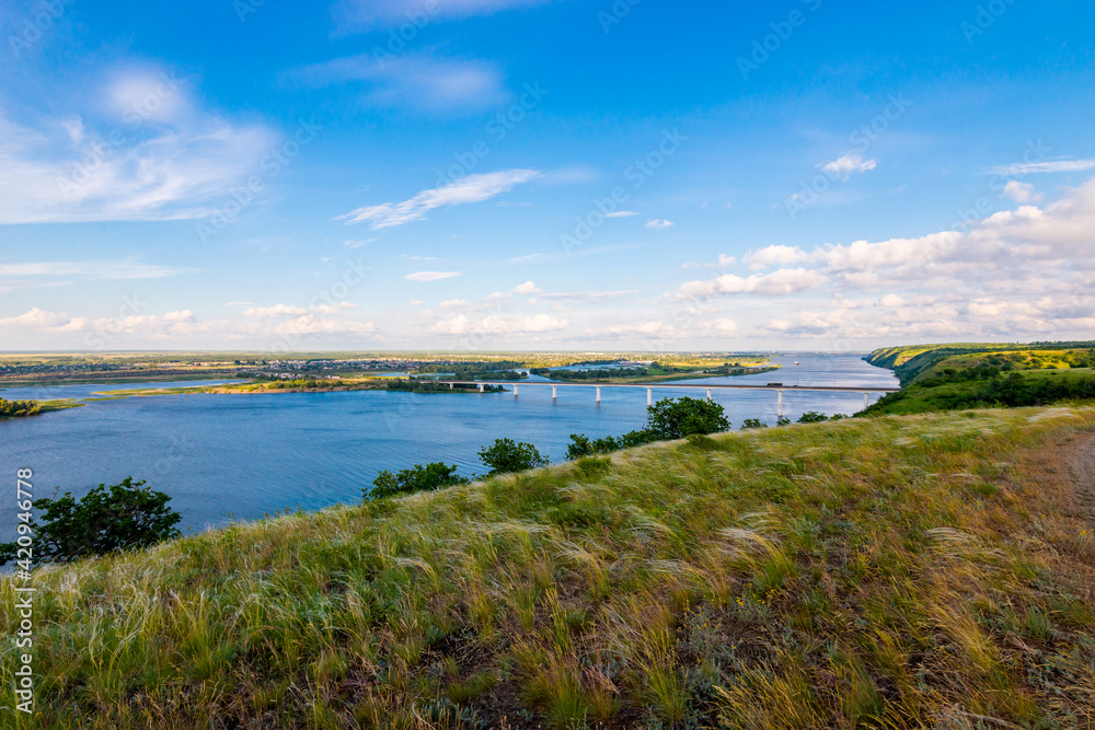 Panoramic view of the road bridge over big river and hills, slopes, steppe coast, gully, ravine on a banks Panoramic view of the road bridge over big river and hills, slopes, steppe coast, gully, ravine on a banks