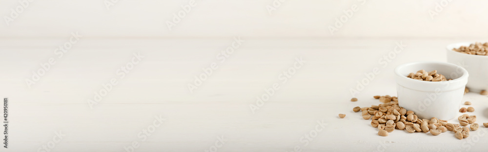 Bowls of coffee beans on light background with space for text Bowls of coffee beans on light background with space for text