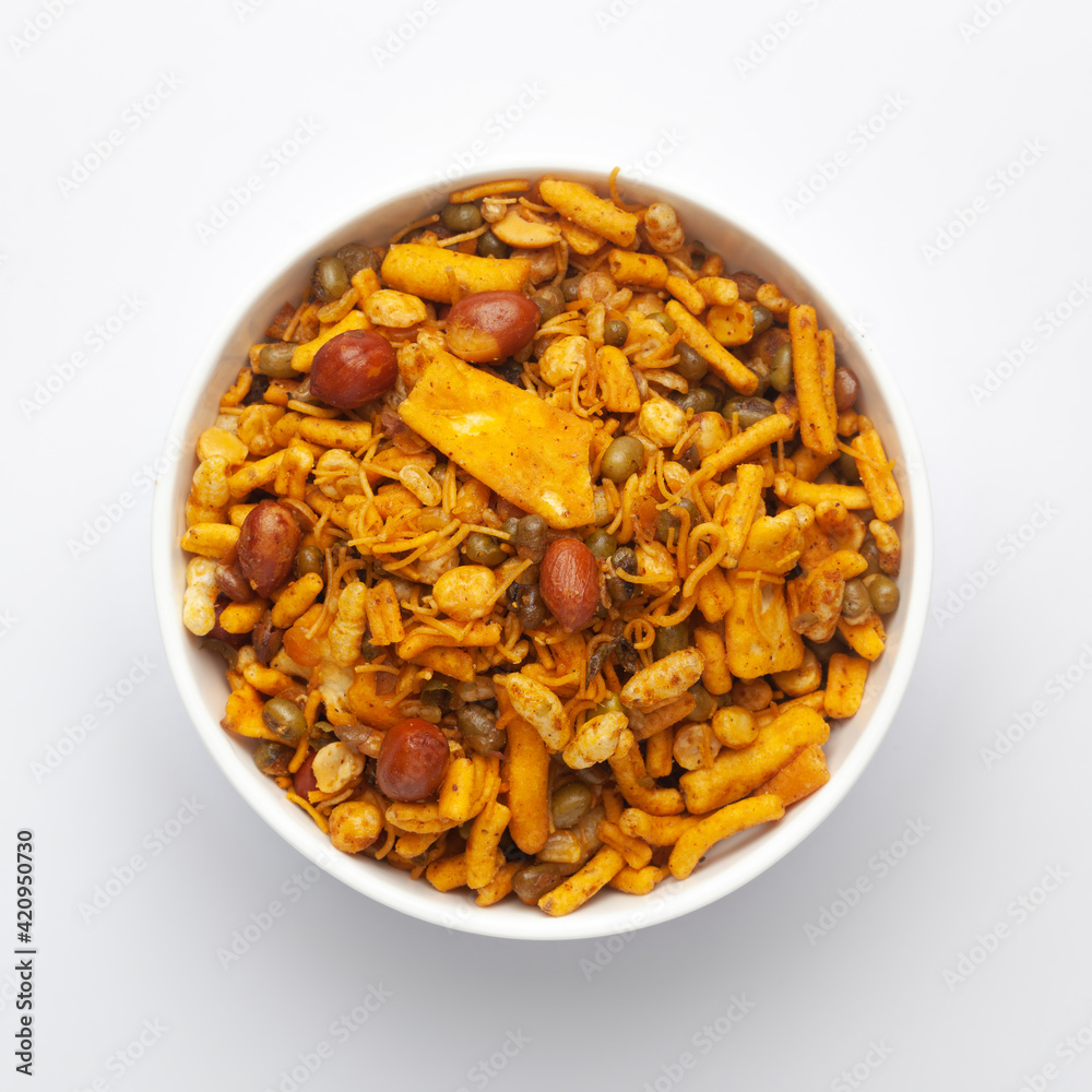 Close up of spicy Ratlami mixture Indian namkeen (snacks) on a ceramic white bowl. Top view Close up of spicy Ratlami mixture Indian namkeen (snacks) on a ceramic white bowl. Top view