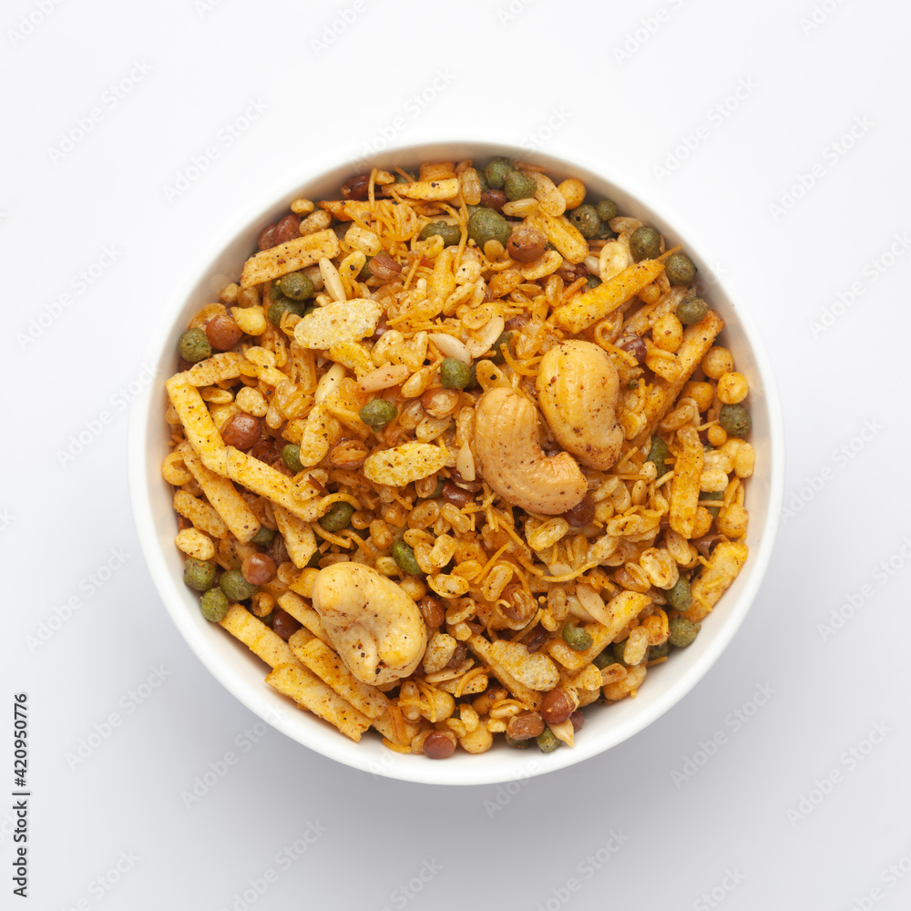 Close up of Rich Spicy Kaju Mixture Indian namkeen (snacks) on a ceramic white bowl. Top view Close up of Rich Spicy Kaju Mixture Indian namkeen (snacks) on a ceramic white bowl. Top view