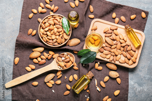 Composition with almond oil and nuts on grunge background