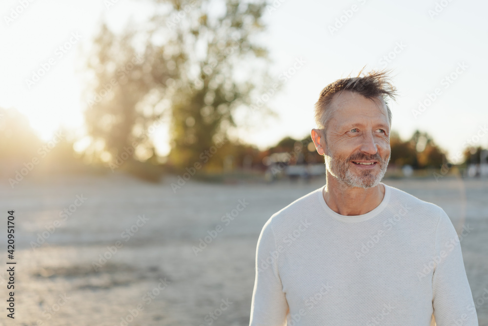 Smiling relaxed happy senior man on a beach at sunrise Smiling relaxed happy senior man on a beach at sunrise