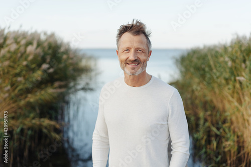Friendly cheerful bearded middle-aged man at the seaside