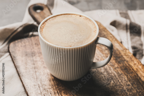 Cup of tasty latte on wooden background