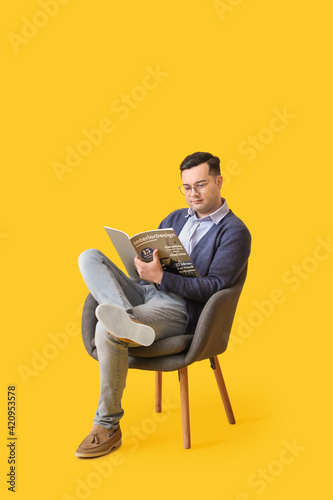 Young man with magazine sit...