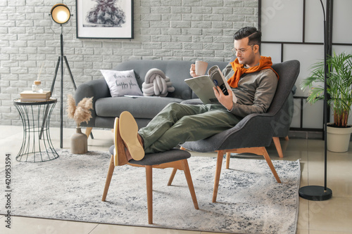 Young man reading magazine ...
