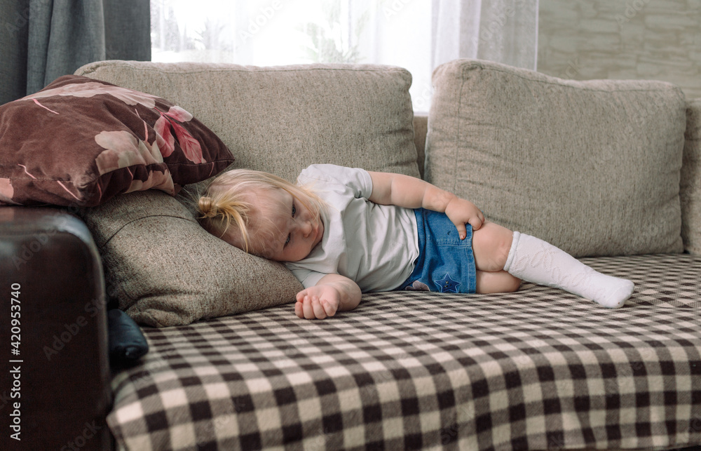 a little girl with a sad face is lying at home on the couch a little girl with a sad face is lying at home on the couch
