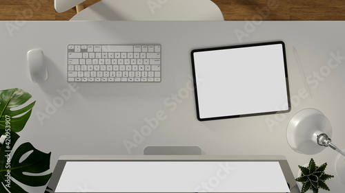 Top view of office desk with digital tablet, computer device, lamp and plant pots in home office room, 3D rendering