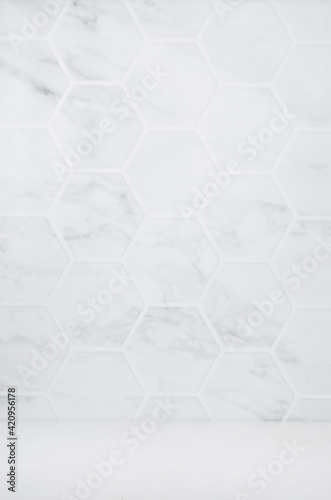 Fototapeta Naklejka Na Ścianę i Meble -  Light white grey marble hexagon tile wall with white wood board as floor, empty interior for presentation, display, design, vertical.