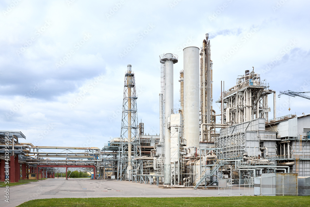 Large-capacity ammonia production workshop. Exterior of modern petrochemical plant with reactors and converters under heavy sky with copyspace.