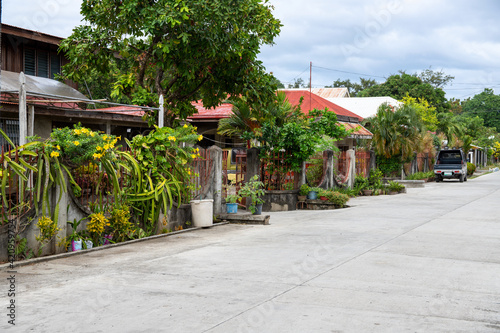 Asian village street view with modern houses and green plants. Tropical island native village view with no people. Philippines architectural style. Apartment rent or lease concept banner template © Elya.Q